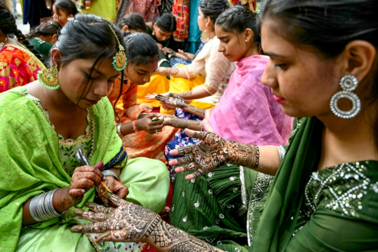 Des étudiantes se tatouent les mains au henné, le 3 août 2024 à Amritsar, en Inde ( AFP / Narinder NANU )