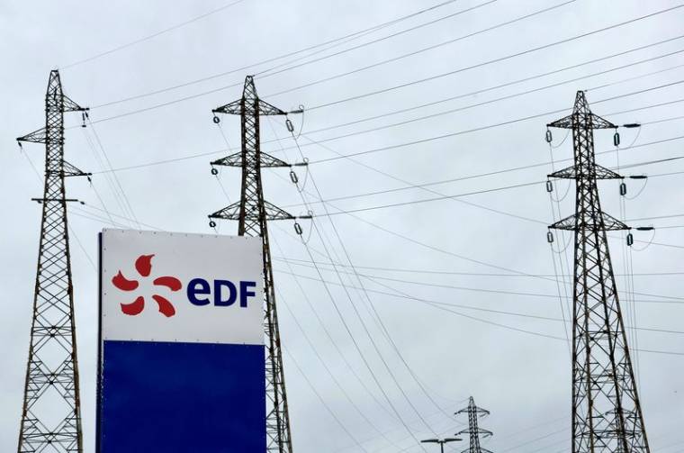 Le logo d'EDF devant des lignes électriques de la centrale nucléaire du Tricastin à Saint-Paul-Trois-Châteaux, France