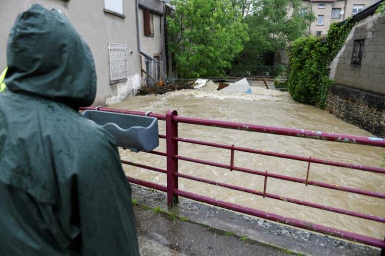 Un habitant regarde l'eau monter sur un pont à Boulay, en Moselle, le 17 mai 2024 ( AFP / Jean-Christophe VERHAEGEN )