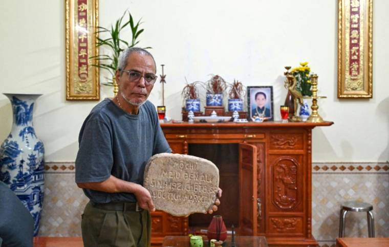 Le Tuan Binh (El Mekki Ali) montre la pierre tombale de son père Mohammed, ou Mzid Ben Ali selon l'inscription, décédé en 1968, à son domicile, dans la province de Phu Tho, le 11 avril 2024 au Vietnam ( AFP / Nhac NGUYEN )