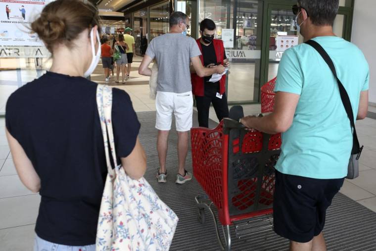 Des clients devant un supermarché en France, le 16 août 2021. ( AFP / PASCAL POCHARD-CASABIANCA )