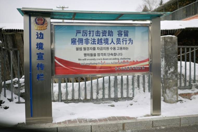 Un panneau de la police mettant en garde contre l'aide aux migrants transfrontaliers illégaux à Changbai, dans la province de Jilin, le 1er mars 2024 dans le nord-est de la Chine ( AFP / Pedro PARDO )
