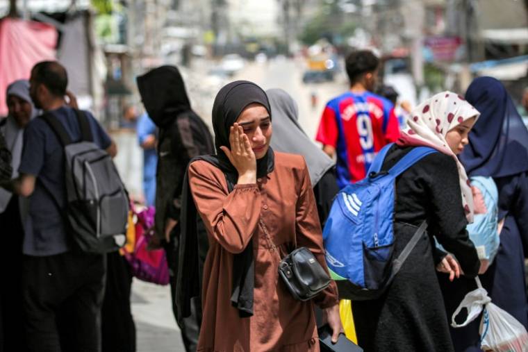 Une Palestinienne attend avec d'autres avant d'évacuer Rafah, dans le sud de la bande de Gaza, le 11 mai 2024 ( AFP / - )