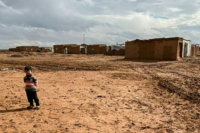 Photo fournie par le Groupe de travail d'urgence syrien (SETF), le 17 mai 2024, montrant un enfant syrien déplacé devant des maisons en terre battue du camp de Rokbane, situé dans le sud de la Syrie, à la frontière avec l'Irak et la Jordanie ( Syrian Emergency Task Force / - )