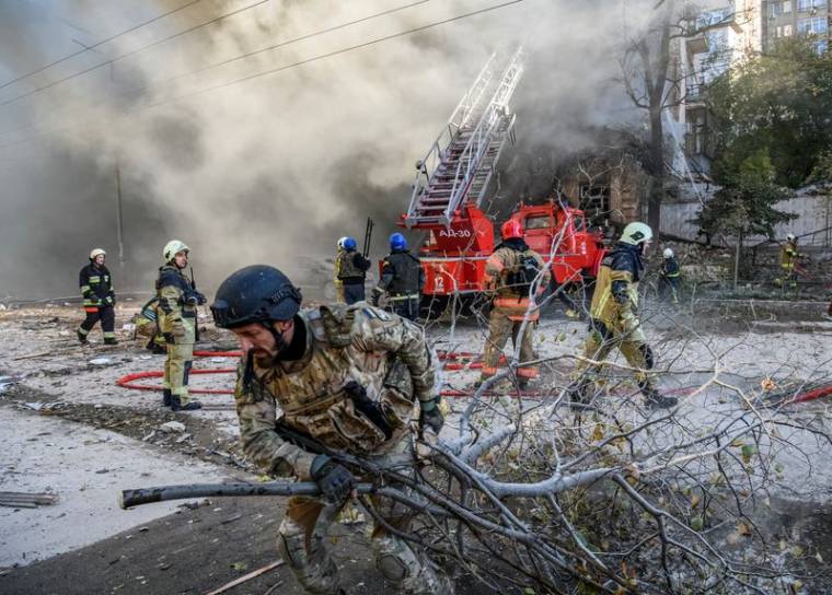 Des pompiers aident à évacuer un immeuble détruit par une frappe de drone russe à Kyiv, en Ukraine