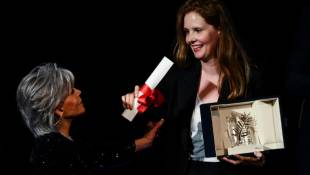 La réalisatrice française Justine Triet (d) reçoit la Palme d'or du 76e Festival de Cannes, des mains de l'actrice américaine Jane Fonda, pour "Anatomie d'une chute", le 27 mai 2023 ( AFP / CHRISTOPHE SIMON )
