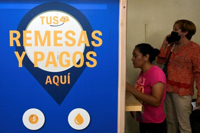 Une femme retire des dollars qu'elle a reçus de parents émigrés aux Etats-Unis,  le 8 avril 2024à Tegucigalpa, au Honduras ( AFP / Orlando SIERRA )