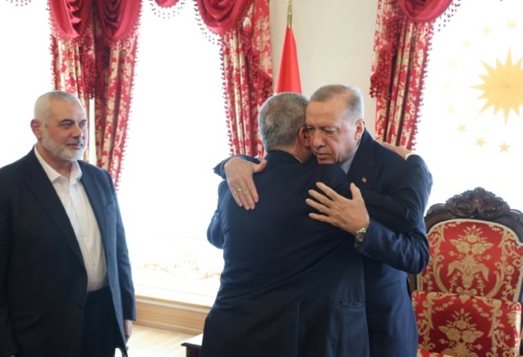 Photo transmise par la présidence turque le 20 avril 2024 montrant le président turc Recep Tayyip Erdogan (D) donnant l'accolade à Khaled Mechaal, l'un des principaux dirigeants du Hamas, lors d'une rencontre avec le chef du Hamas, Ismaïl Haniyeh (G)à Istanbul ( TURKISH PRESIDENTIAL PRESS SERVICE / Handout )