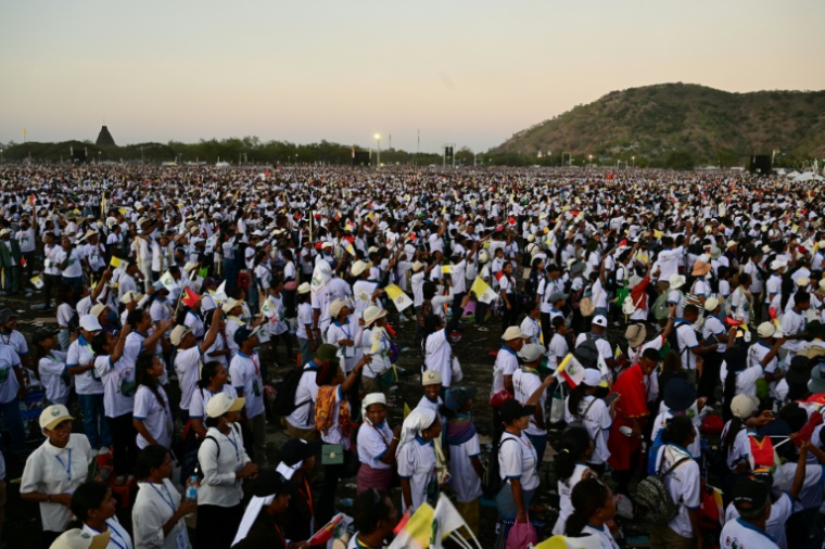 Les fidèles réagissent à l'approche du crépuscule lors de la messe célébrée par le pape François sur l'esplanade de Tasitolu à Dili, au Timor oriental, le 10 septembre 2024. ( AFP / Tiziana FABI )