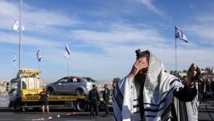 Un juif religieux réagit à la scène d'une attaque meurtrière par balles à Jérusalem le 30 novembre 2023 ( AFP / RONALDO SCHEMIDT )