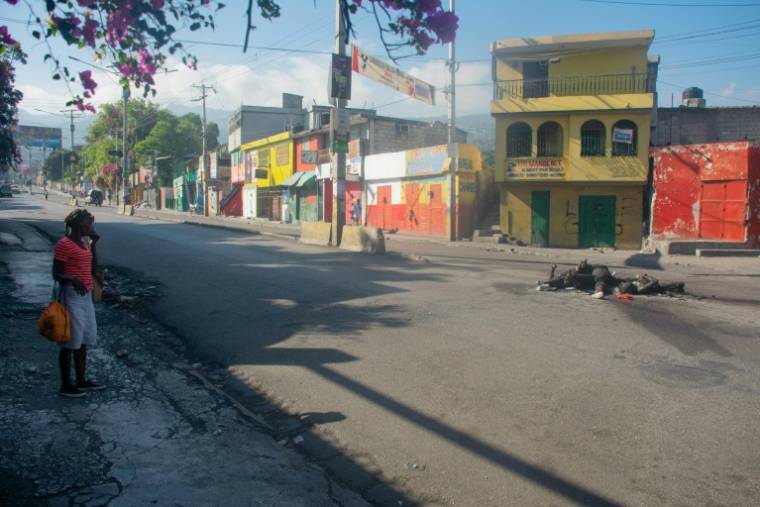 Une femme regarde des corps calcinés à Port-au-Prince le 22 mars 2024 ( AFP / Clarens SIFFROY )