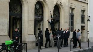 Un agent de sécurité retire une affiche de l'entrée de Sciences Po Paris, après que des étudiants ont pénétré à l'intérieur pour un rassemblement propalestinien, le 7 mai 2024 à Paris ( AFP / Dimitar DILKOFF )