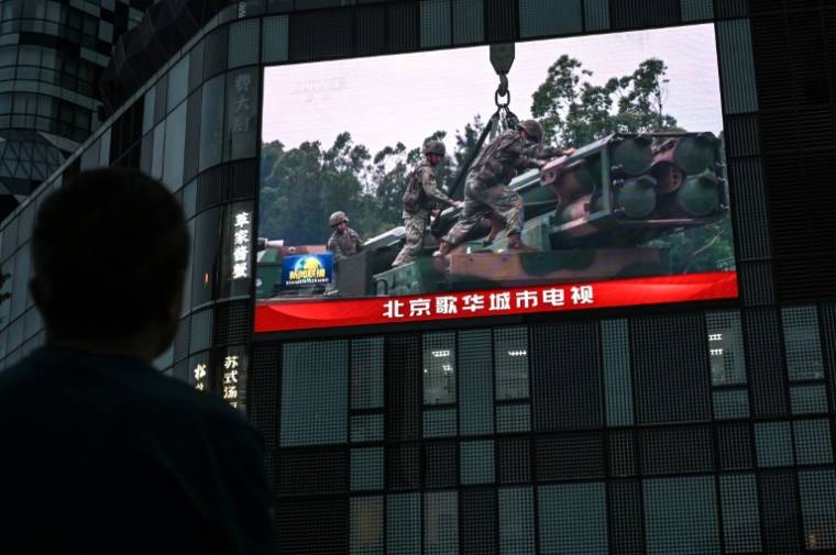 Un écran géant diffuse des images des exercices militaires chinois autour de Taïwan, le 23 mai 2024 à Pékin ( AFP / Jade Gao )