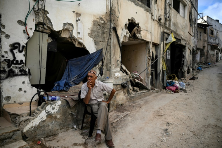 Un homme est assis devant un bâtiment détruit après une vaste opération "antiterroriste" israélienne en Cisjordanie occupée, le 6 septembre 2024, à Jénine, dans le nord du territoire ( AFP / RONALDO SCHEMIDT )