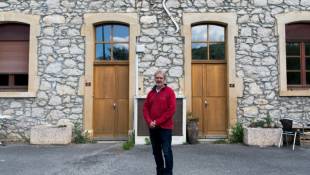 Le maire de Montardit, Eric Couzinet, devant une maison avec des entrées numérotées, le 31 mai 2024 en Ariège ( AFP / Matthieu RONDEL )