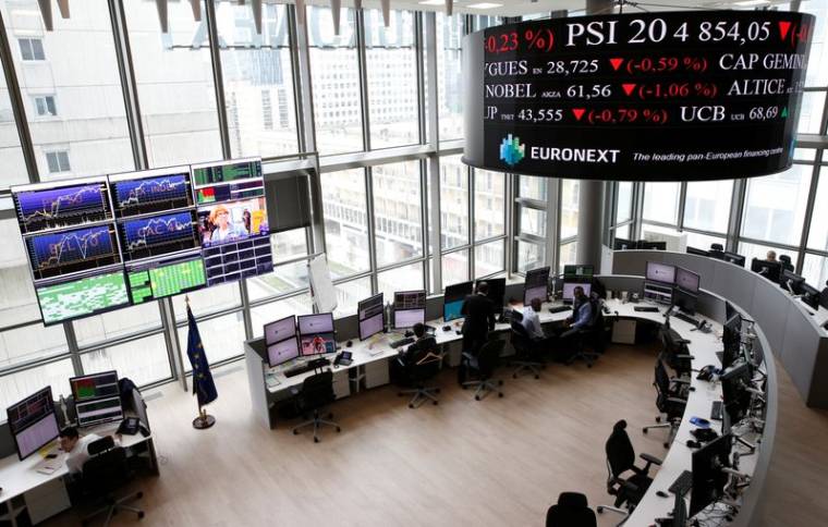 Traders work at their desks in a trading room at the stock market operator Euronext headquarters in La Defense business and financial district in Courbevoie near Paris