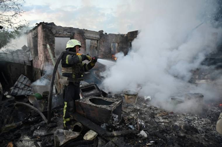 Des pompiers éteignent un incendie après une attaque de drones russes dans les environs de Kharkiv, le 21 mai 2024 en Ukraine ( AFP / SERGEY BOBOK )