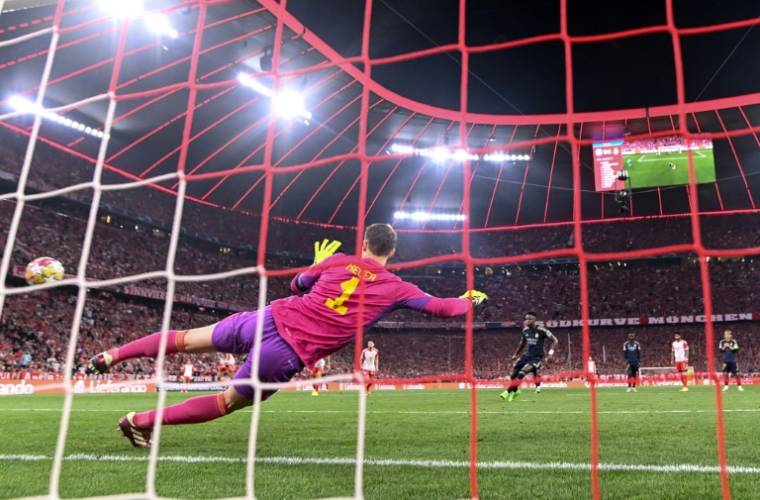 L'attaquant du Real Madrid Vinicius Jr marque le pénalty du 2-2 à la 83e minute contre le gardien du Bayern Manuel Neuer. ( AFP / Kirill KUDRYAVTSEV )