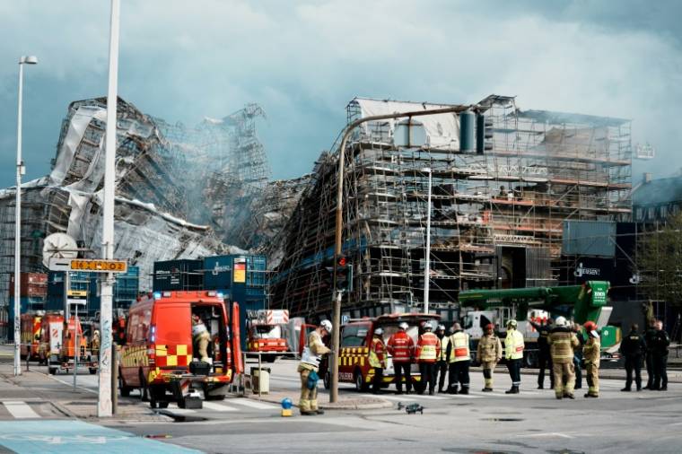 Des pompiers devant la façade principale de l'ancienne Bourse de Copenhague qui s'est effondrée, deux jours après un incendie qui l'a ravagée, le 18 avril 2024 au Danemark ( Ritzau Scanpix / Thomas Traasdahl )