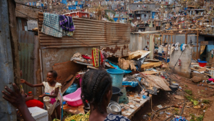 De jeunes habitantes du bidonville de Kawéni à Mamoudzou au milieu des décombres après le passage du cyclone Chido, le 20 décembre 2024 ( AFP / DIMITAR DILKOFF )