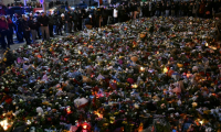 Des personnes se recueillent devant un mémorial composé de fleurs et de bougies en hommage aux victimes d'un attentat à la voiture bélier sur un marché de Noël, à Magdebourg, le 23 décembre 2024 en Allemagne ( AFP / RALF HIRSCHBERGER )