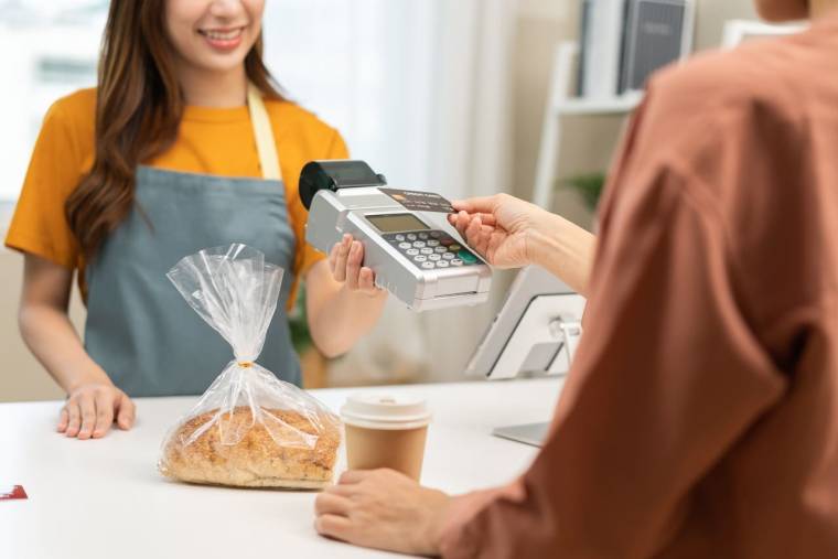 (Crédits photo : Adobe Stock - Homme payant son pain à la boulangerie avec sa carte bancaire en sans contact)