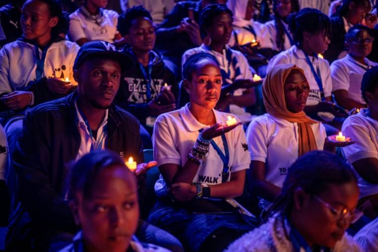 Des jeunes Rwandais assistent à une veillée nocturne en souvenir des victimes du génocide de 1994, au BK Arena de Kigali, le 7 avril 2024 ( AFP / LUIS TATO )