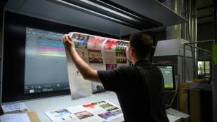 Un employé de l'imprimerie professionnelle L'Atelier Print vérifie l'impression de documents, le 14 juin 2024 à Toulouse ( AFP / Ed JONES )