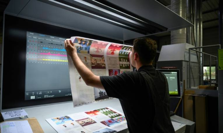 Un employé de l'imprimerie professionnelle L'Atelier Print vérifie l'impression de documents, le 14 juin 2024 à Toulouse ( AFP / Ed JONES )