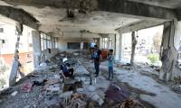 Des membres d'une équipe d'enquête des Nations Unies dans les décombres d'une école de l'agence de l'ONU pour les réfugiés palestiniens (Unrwa) touchée la veille par un bombardement israélien à Nousseirat, dans le centre de la bande de Gaza, le 7 juin 2024  ( AFP / Eyad BABA )