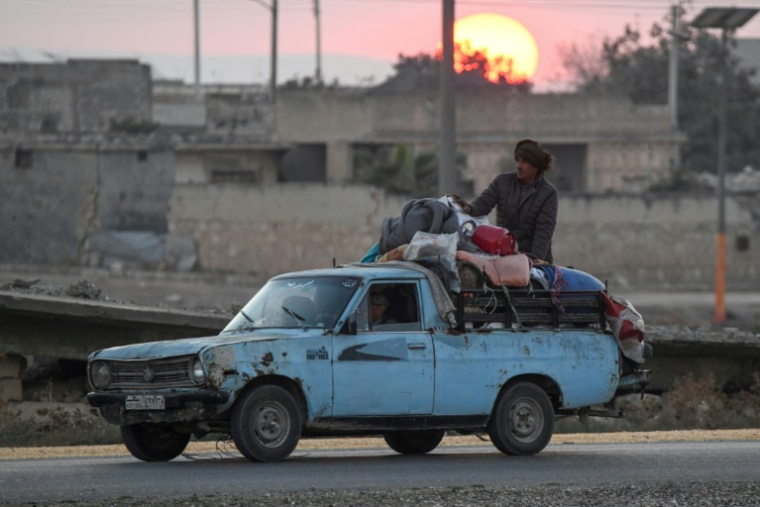 Des Syriens kurdes déplacés fuient la périphérie de la ville d'Alep, dans le nord du pays, qui étaient autrefois contrôlées par les Forces démocratiques syriennes (FDS) dirigées par les Kurdes, après avoir que des rebelles dirigés par les islamistes ont pris la zone, le 2 décembre 2024 ( AFP / Rami al SAYED )