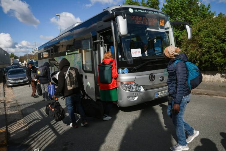 Des bus attendent les migrants évacués pour les amener dans des structures d'accueil provisoires, à Vitry-sur-Seine, le 17 avril 2024 ( AFP / Emmanuel Dunand )