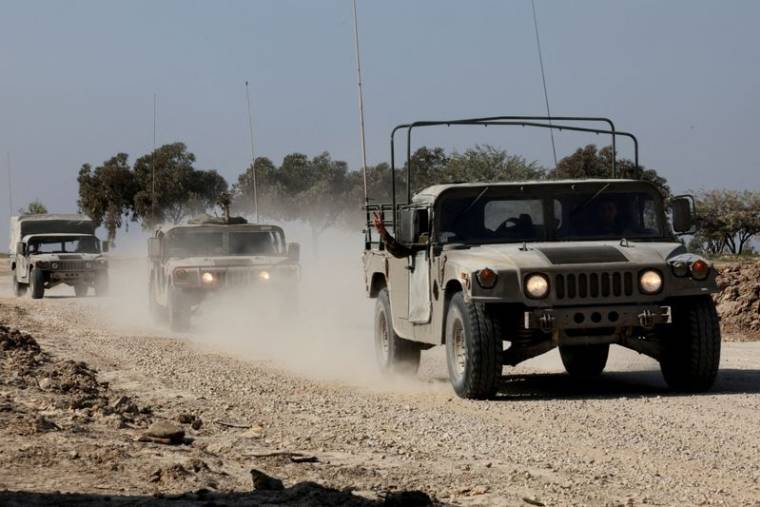Des véhicules militaires israéliens se déplacent près de la frontière entre Israël et Gaza