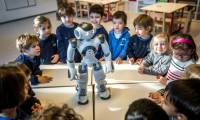 Des élèves de maternelle interagissent avec le robot éducatif et interactif Nao dans un établissement sur le campus universitaire de l'École polytechnique fédérale de Lausanne, en Suisse, le 23 février 2024 ( AFP / Fabrice COFFRINI )