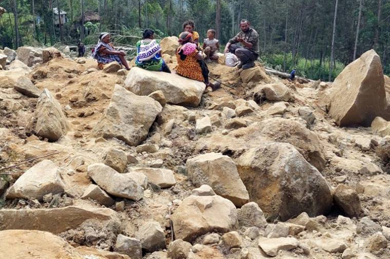 Des membres de la famille de villageois disparus sont présents sur le site d'un glissement de terrain au village de Mulitaka, dans la province d'Enga en Papouasie-Nouvelle-Guinée, le 26 mai 2024 ( AFP / STR )