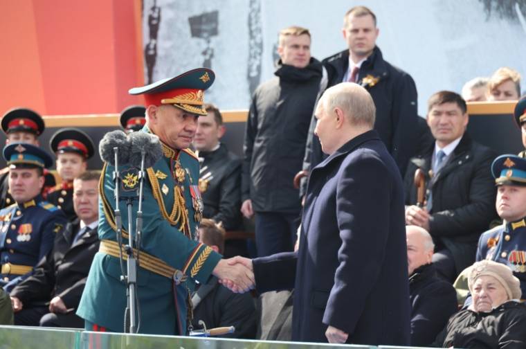 Le président russe Vladimir Poutine (d) serre la main du ministre de la Défense Sergueï Choïgou lors du défilé militaire du Jour de la Victoire sur l'Allemagne nazie, le 9 mai 2024 à Moscou ( POOL / Mikhail KLIMENTYEV )