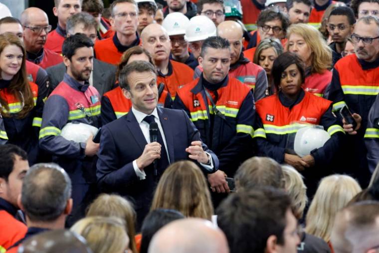 Le président français Emmanuel Macron parle à des employés d'une usine de production de batteries pour voitures électriques à Dunkerque, dans le Nord, le 12 mai 2023 ( POOL / PASCAL ROSSIGNOL )