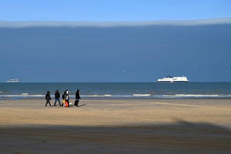 Des migrants sur une plage de Sangatte, dans le Pas-de-Calais, après avoir échoué à traverser illégalement la Manche pour atteindre la Grande-Bretagne, le 15 décembre 2023 ( AFP / BERNARD BARRON )