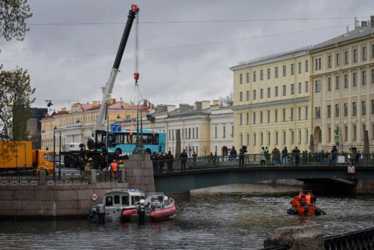 Les secours auprès d'un bus qui a chuté dans une rivière à Saint-Pétersbourg, en Russie, avec une vingtaine de personnes à bord dont plusieurs sont décédées, le 10 mai 2024 ( AFP / Olga MALTSEVA )