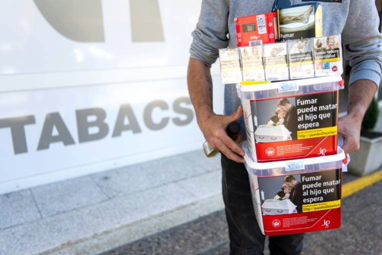 Un hommes porte des paquets de tabac achetéd dans une boutique de Les, en Espagne, le 19 avril 2024 ( AFP / Matthieu RONDEL )
