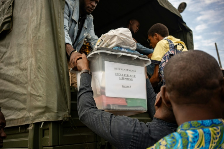 Des urnes remplies de matériel électoral sont distribuées dans les bureaux de vote avant le référendum sur une nouvelle Constitution au Gabon, à Libreville le 16 novembre 2024 ( AFP / NAO MUKADI )