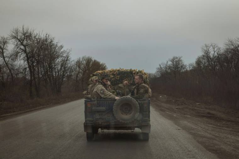 Des soldats ukrainiens à l'arrière d'un véhicule militaire sur une route près de Tchassiv Iar, dans la région de Donetsk, le 2 avril 2024 ( AFP / Roman PILIPEY )