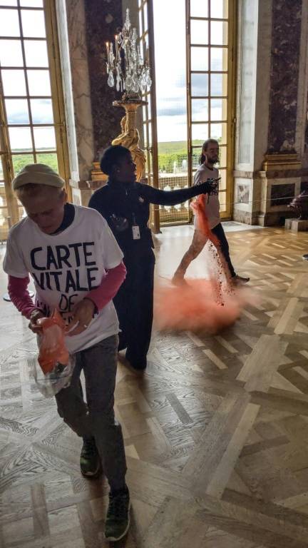 Des militants de Riposte alimentaire jetent de la poudre orange dans la galerie des glaces du château de Versailles, le 4 mai 2024 ( Riposte Alimentaire / - )