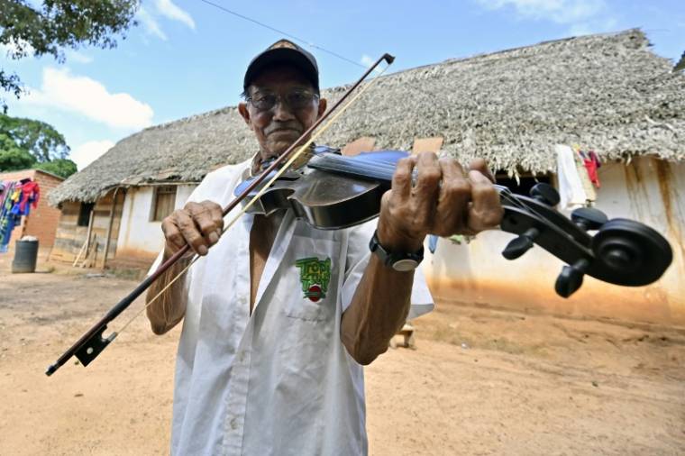 Le luthier Hildeberto Oreyai joue du violon devant sa maison à Urubichá, en Bolivie, le 22 avril 2024 ( AFP / AIZAR RALDES )