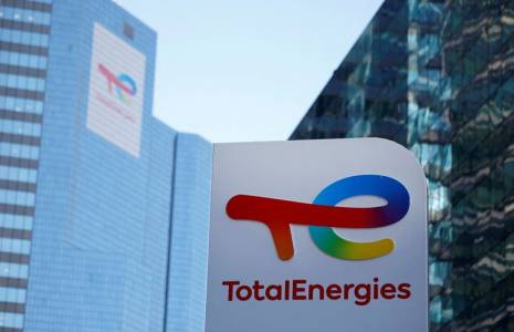 Un logo de TotalEnergies est visible à une station de ravitaillement pour véhicules électriques