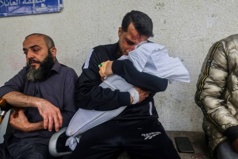 Un Palestinien étreint le corps de l'une de ses deux filles, tuées dans un bombardement israélien sur Rafah, dans le sud de la bande de Gaza, le 4 avril 2024 ( AFP / Mohammed ABED )