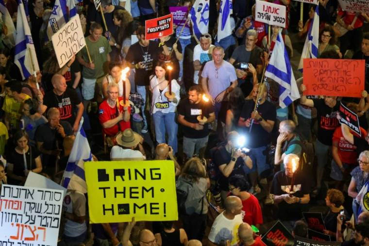 Des Israéliens allument des bougies lors d'une manifestation appelant à la libération des otages retenus à Gaza, dans la ville côtière de Tel Aviv, le 18 mai 2024 ( AFP / JACK GUEZ )