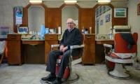 Le coiffeur Roger Amilhastre, âgé de 90 ans,  dans son salon à Saint-Girons, en Ariège, le 16 avril 2024  ( AFP / Ed JONES )