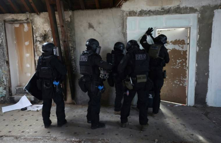 Des membres du Raid participent à une simulation d'attaque terroriste, à l'école de police de Draveil, le 21 mars 2024 dans l'Essonne ( AFP / Emmanuel DUNAND )