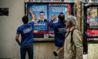 Des bénévoles du RN collent des affiches de campagne de Jordan Bardella, président du parti et tête de liste aux européennes, le 6 mai 2024 à Lyon ( AFP / JEFF PACHOUD )